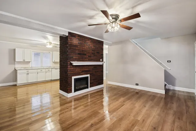a view of a livingroom with wooden floor and a kitchen space with wooden floor