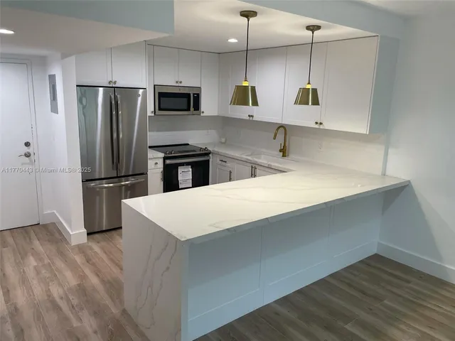 a kitchen with stainless steel appliances a refrigerator sink and microwave