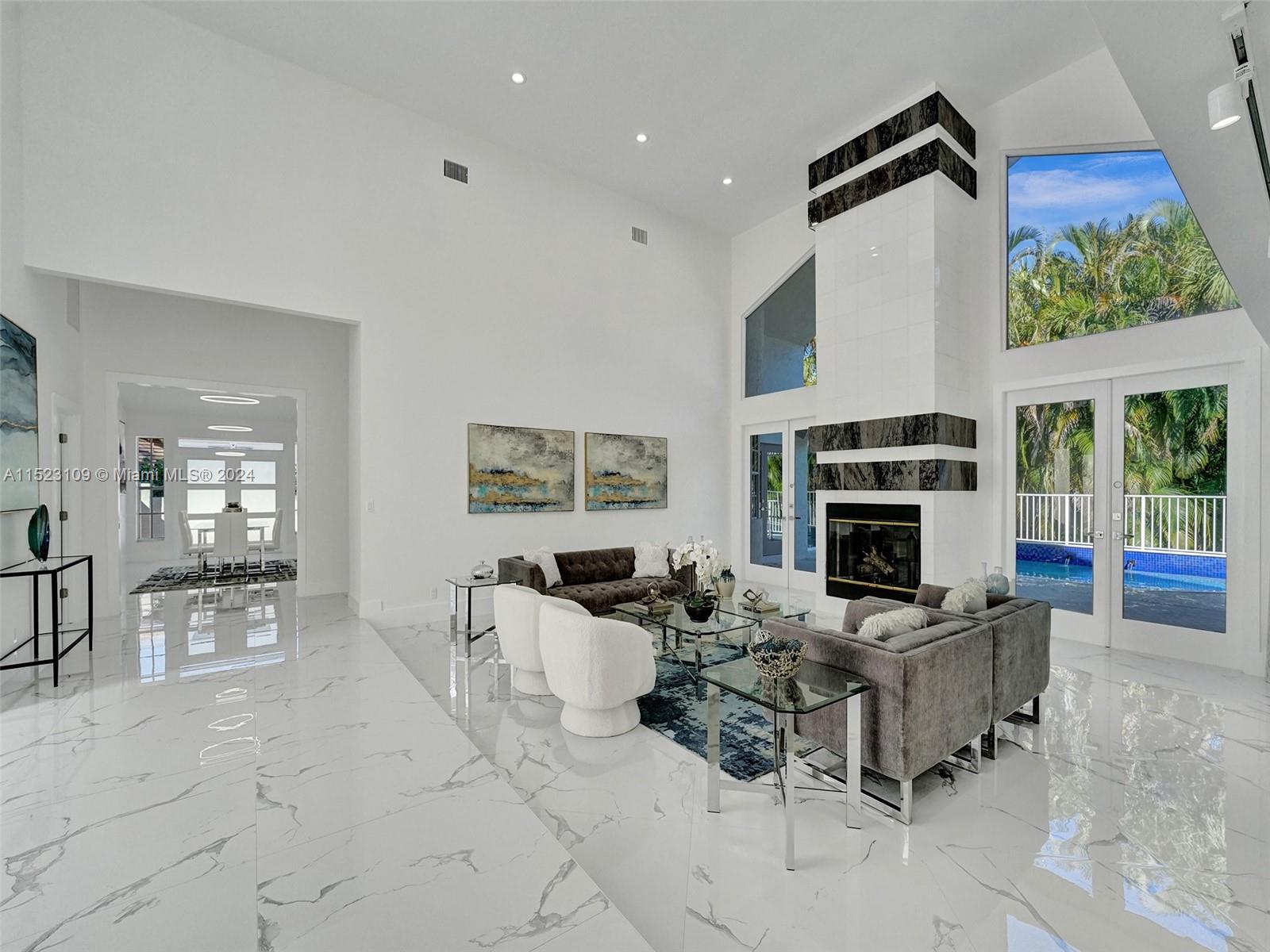791 Parkside Circle North Boca Raton, FL 33486 - Photo 2 of 87 a living room with furniture a fireplace and a floor to ceiling window