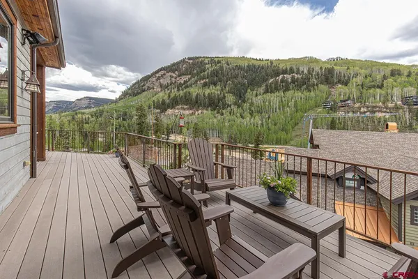 a view of a balcony with wooden floor and outdoor seating
