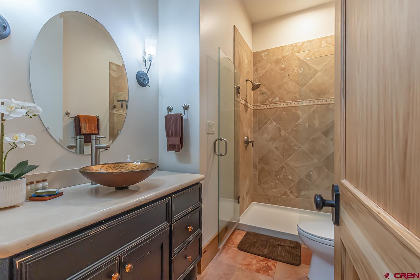 59 Snowden Drive Durango, CO 81301 - Photo 20 of 45 a bathroom with a granite countertop sink a toilet a mirror and shower