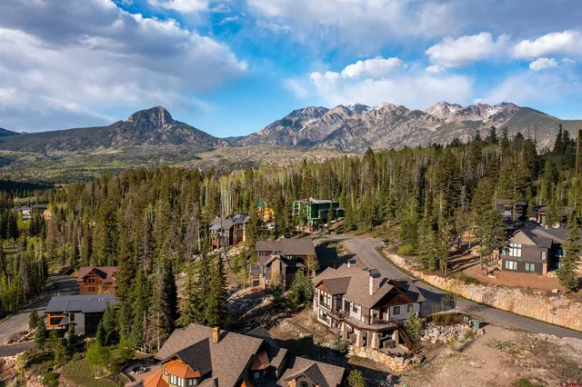 a view of a city with lots of residential buildings ocean and mountain view in back