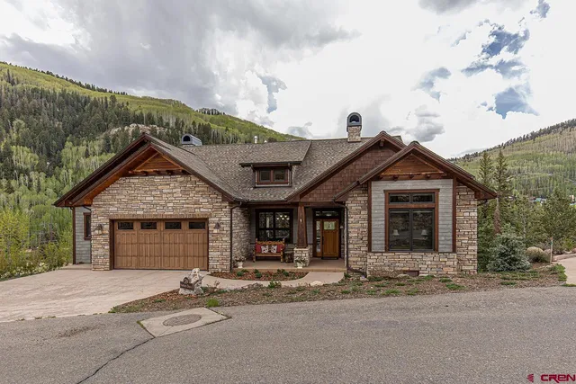 a view of a living room and a dining room with furniture wooden floor and a chandelier