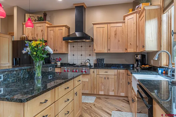 a kitchen with granite countertop a sink stove and cabinets
