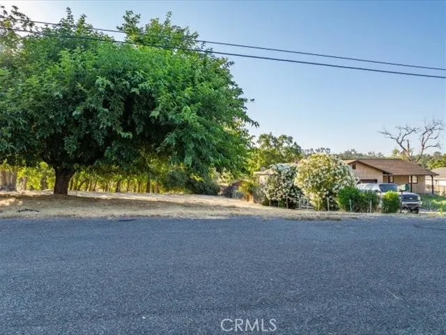 a view of a street with a building and trees in the background