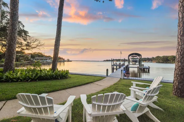 a view of a chair and table on the patio near a lake