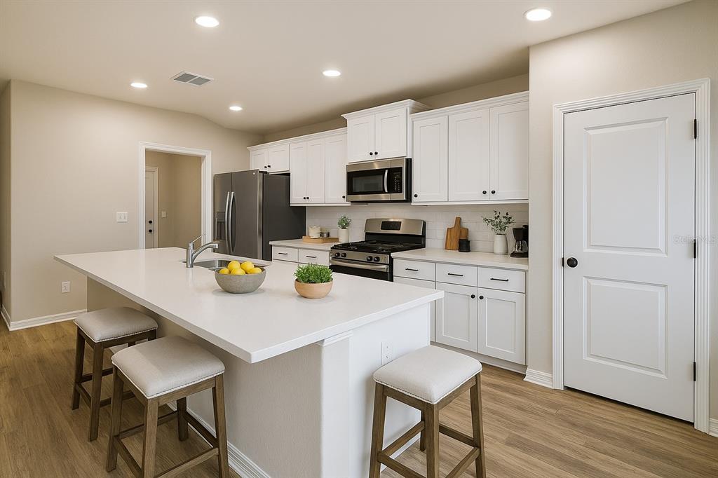 46 Ash Road Ocala, FL 34472 - Photo 6 of 20 a kitchen with a sink a stove and chairs
