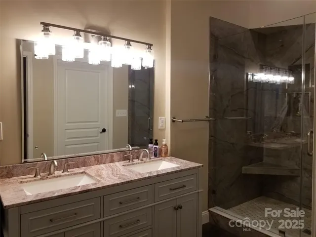 a bathroom with a granite countertop sink shower and a mirror