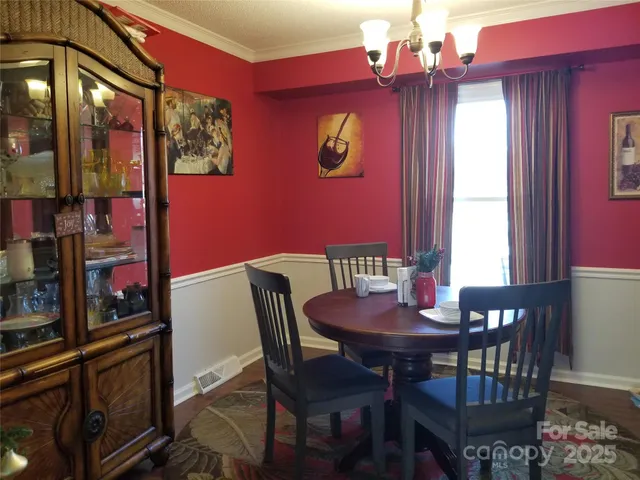 a view of a dining room with furniture and chandelier