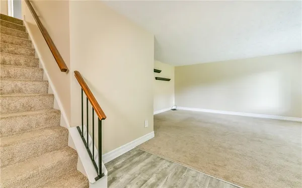 a view of staircase with white walls and white door
