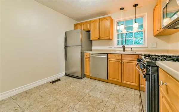 a kitchen with a refrigerator a stove a sink and a window
