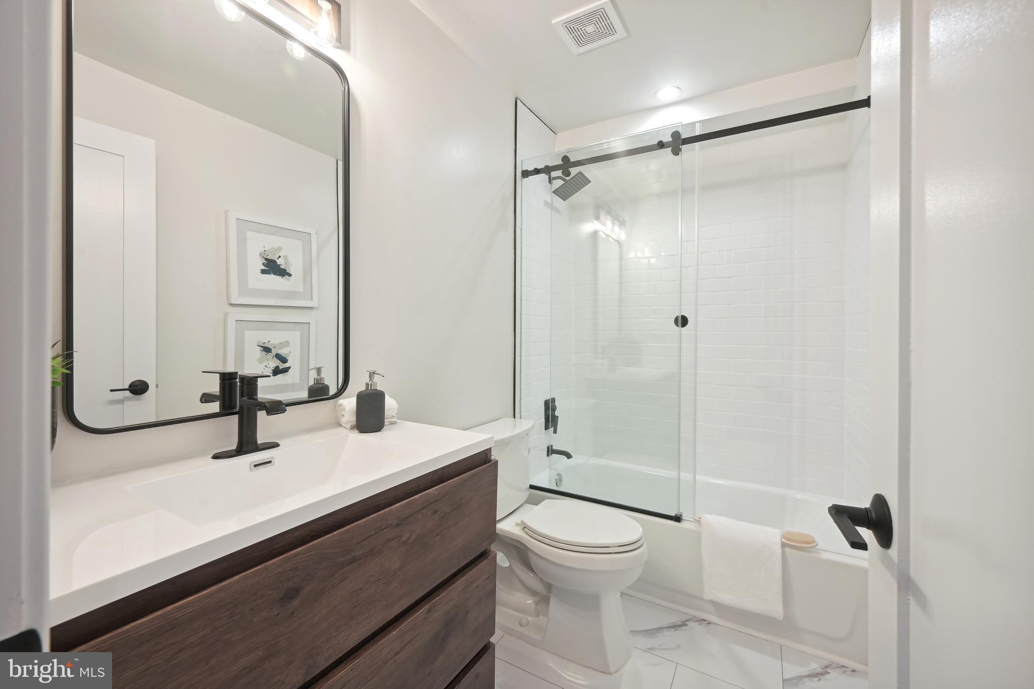 3657 13th Street Northwest Washington, DC 20010 - Photo 32 of 35 a bathroom with a sink toilet a mirror and shower