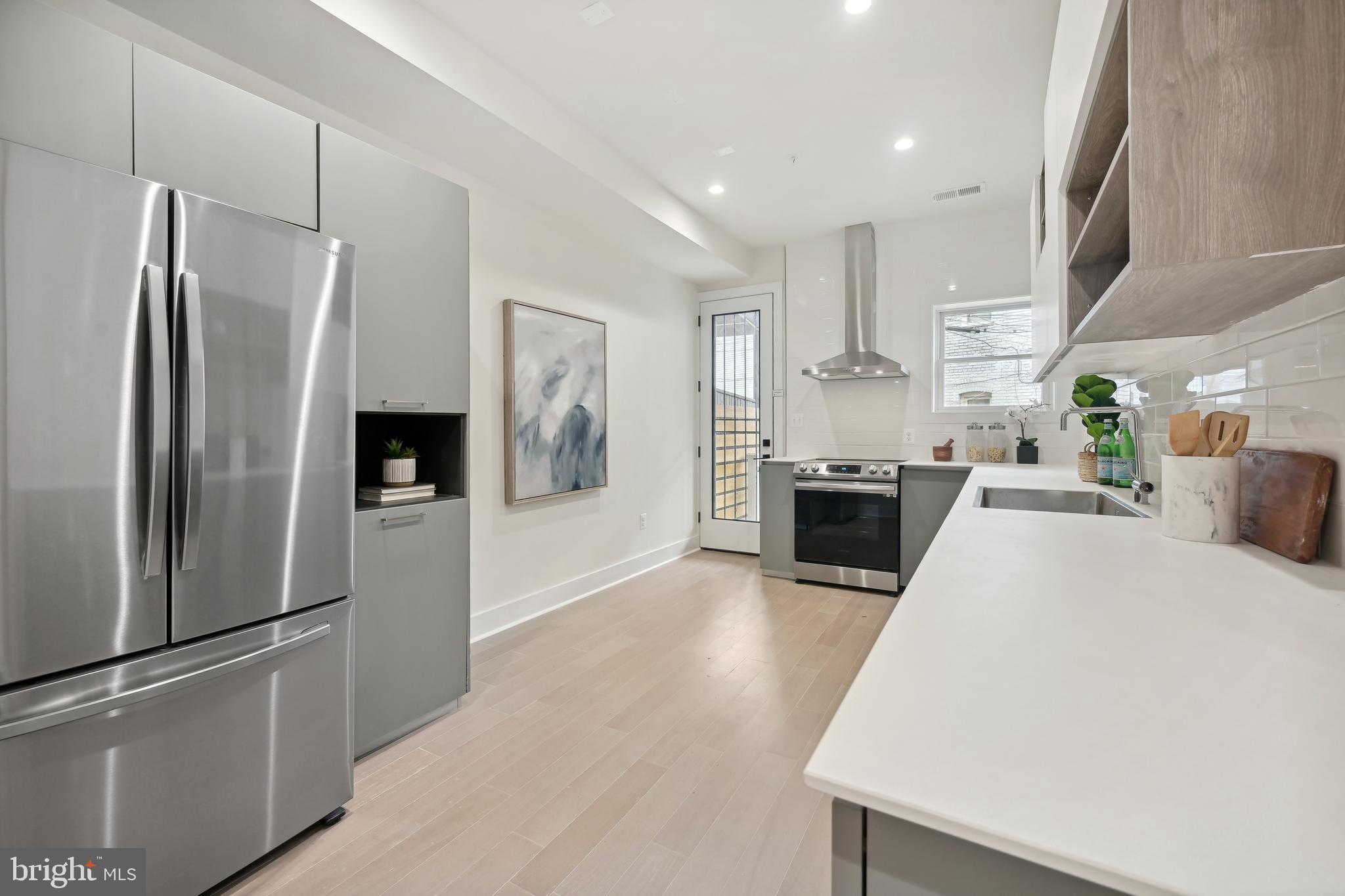 3657 13th Street Northwest Washington, DC 20010 - Photo 6 of 35 a large kitchen with stainless steel appliances a refrigerator and a stove top oven