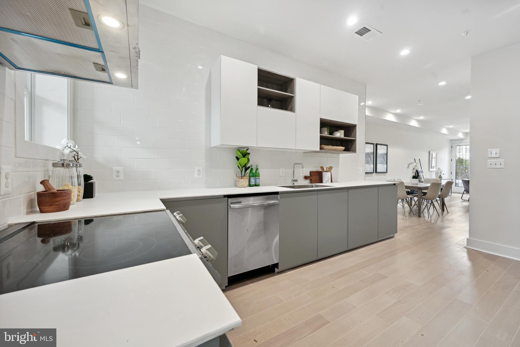 3657 13th Street Northwest Washington, DC 20010 - Photo 7 of 35 a kitchen with stainless steel appliances a sink a stove a microwave a sink a refrigerator and white cabinets