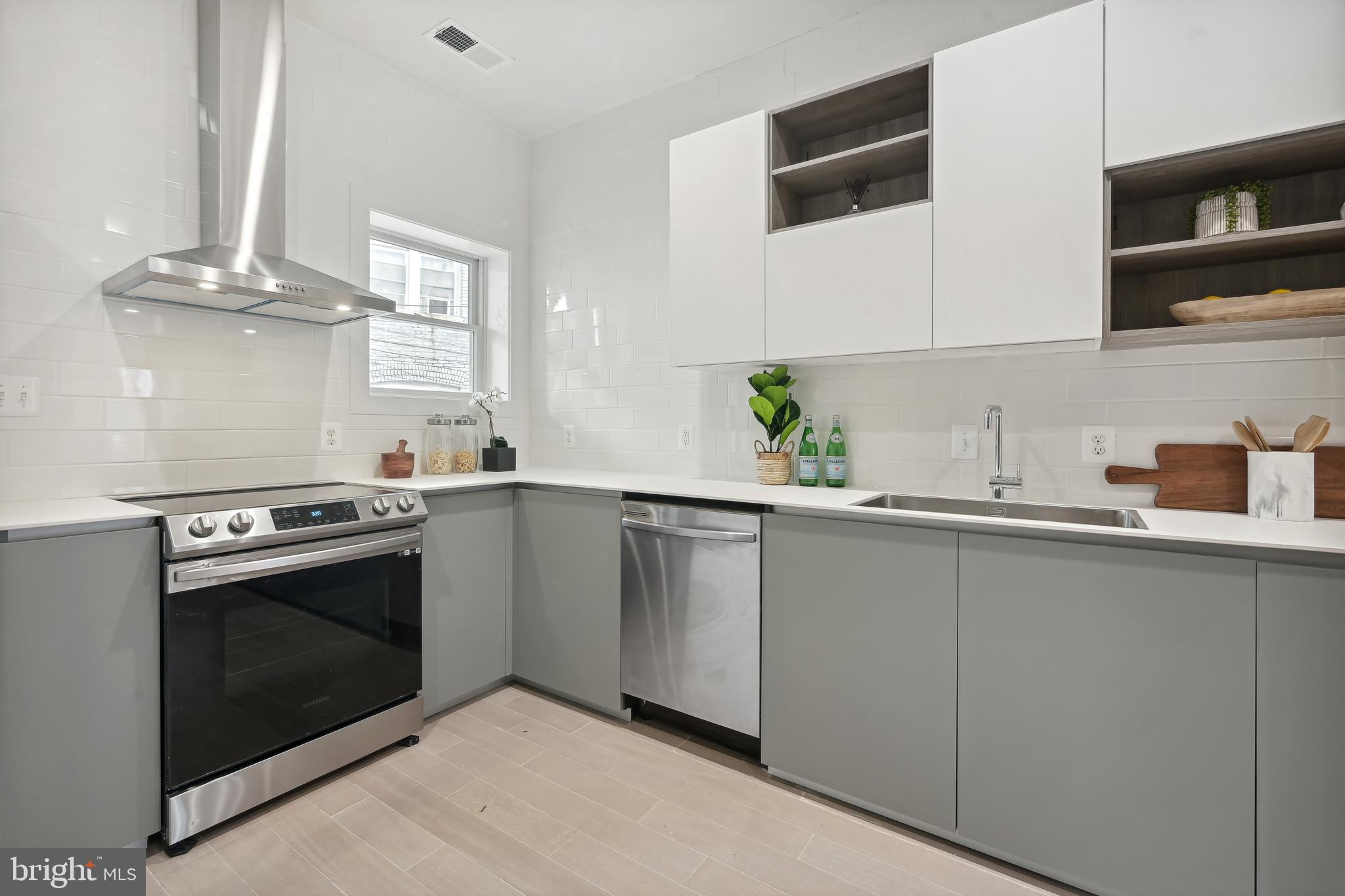 3657 13th Street Northwest Washington, DC 20010 - Photo 9 of 35 a kitchen with stainless steel appliances a sink stove and cabinets