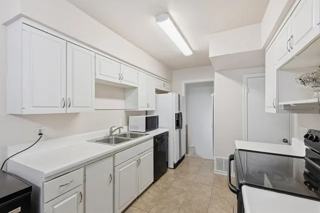 a kitchen with a sink cabinets and stainless steel appliances