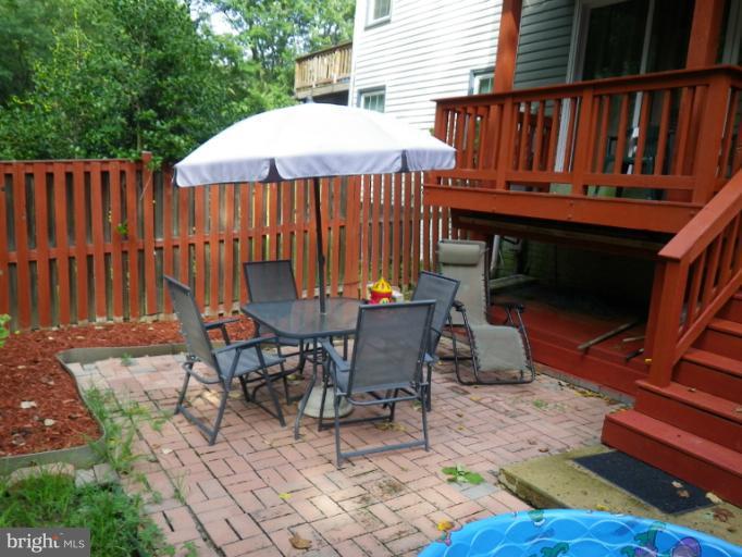 a view of backyard with seating space and wooden fence