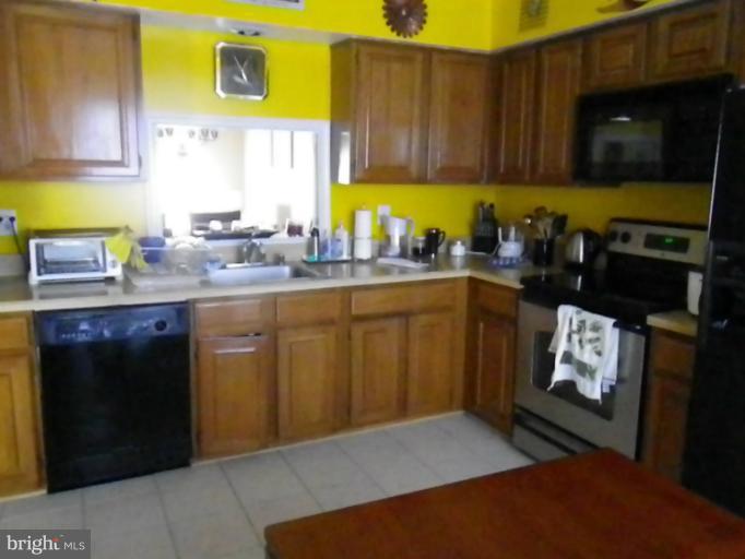 8222 Maple Ridge Avenue Springfield, VA 22153 - Photo 2 of 15 a kitchen with stainless steel appliances granite countertop a sink stove and cabinets