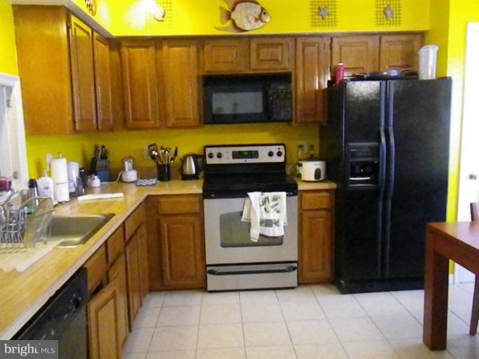 8222 Maple Ridge Avenue Springfield, VA 22153 - Photo 3 of 15 a kitchen with stainless steel appliances granite countertop a refrigerator and a sink