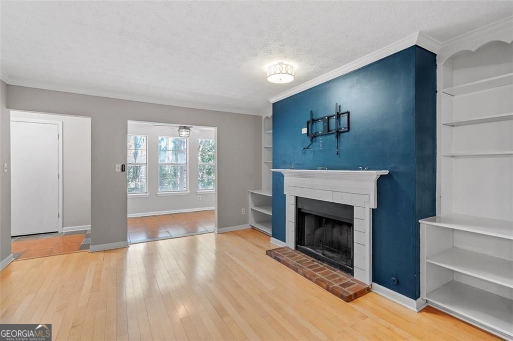 2045 Brian Way Decatur, GA 30033 - Photo 3 of 35 a view of an empty room with wooden floor fireplace and a window