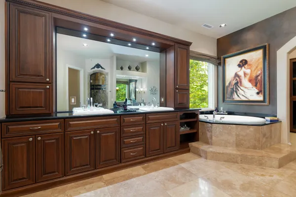 a spacious bathroom with a granite countertop tub sink and mirror