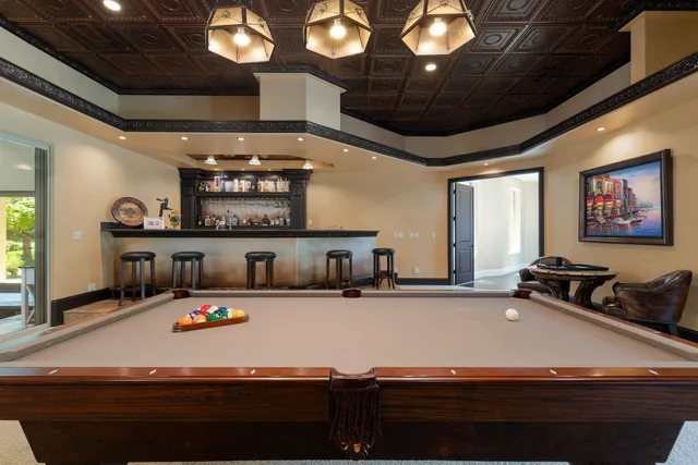 a room with furniture pool table and window