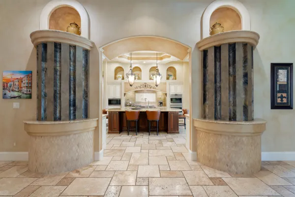 a view of a hallway with entryway a chandelier and a kitchen view