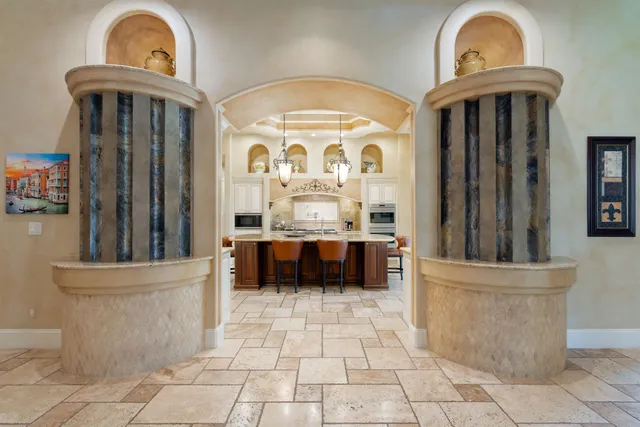 a view of a hallway with entryway a chandelier and a kitchen view