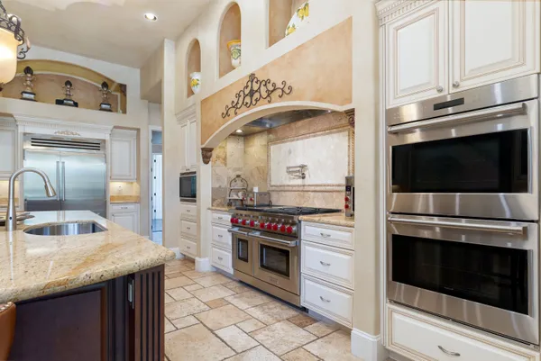 a kitchen with stainless steel appliances granite countertop a stove microwave and cabinets
