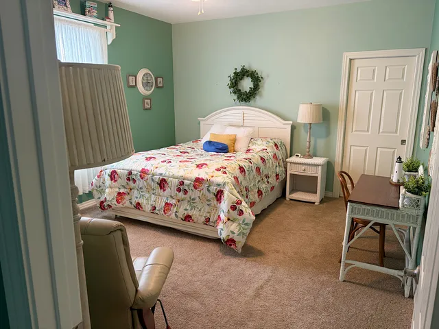 a bedroom with a bed and a chair in it