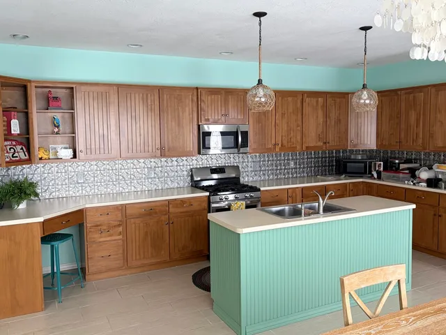 a kitchen with a sink a stove and a wooden cabinets