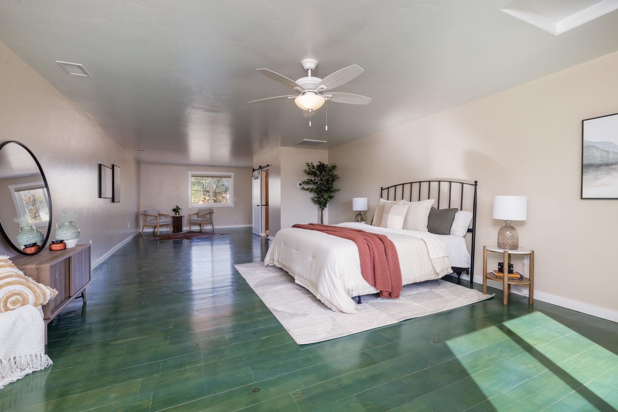 2877 B Road Grand Junction, CO 81503 - Photo 23 of 36 a spacious bedroom with a bed a mirror and lamp on table