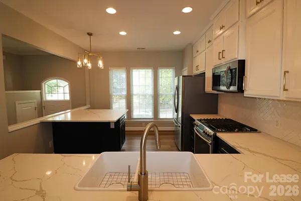 a kitchen with stainless steel appliances kitchen island granite countertop a stove a sink and a microwave