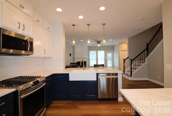 a kitchen with stainless steel appliances granite countertop a stove a sink and a microwave