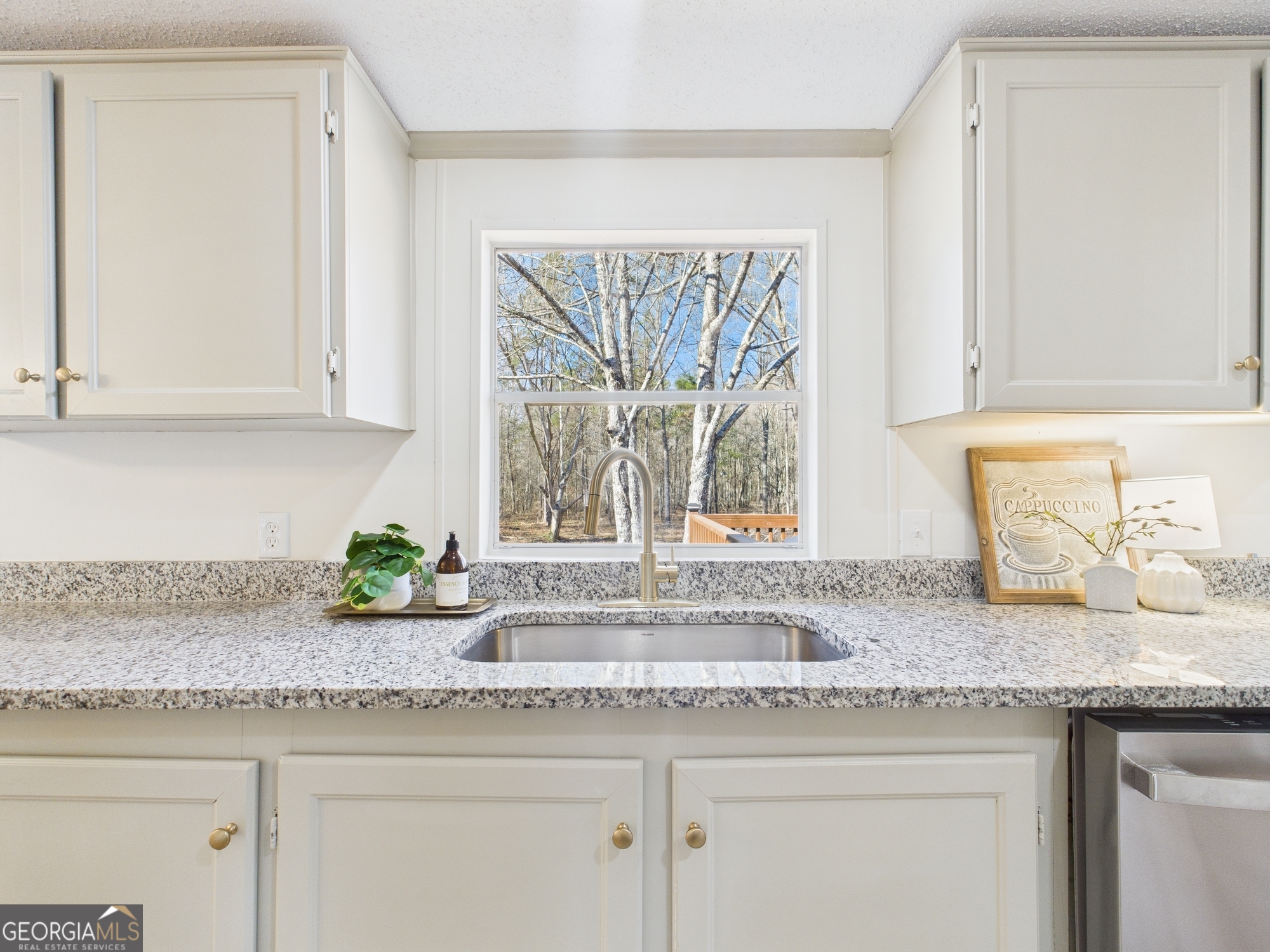 1669 Henderson Road Macon, GA 31217 - Photo 13 of 48 a kitchen with granite countertop a sink a window and a white counter top