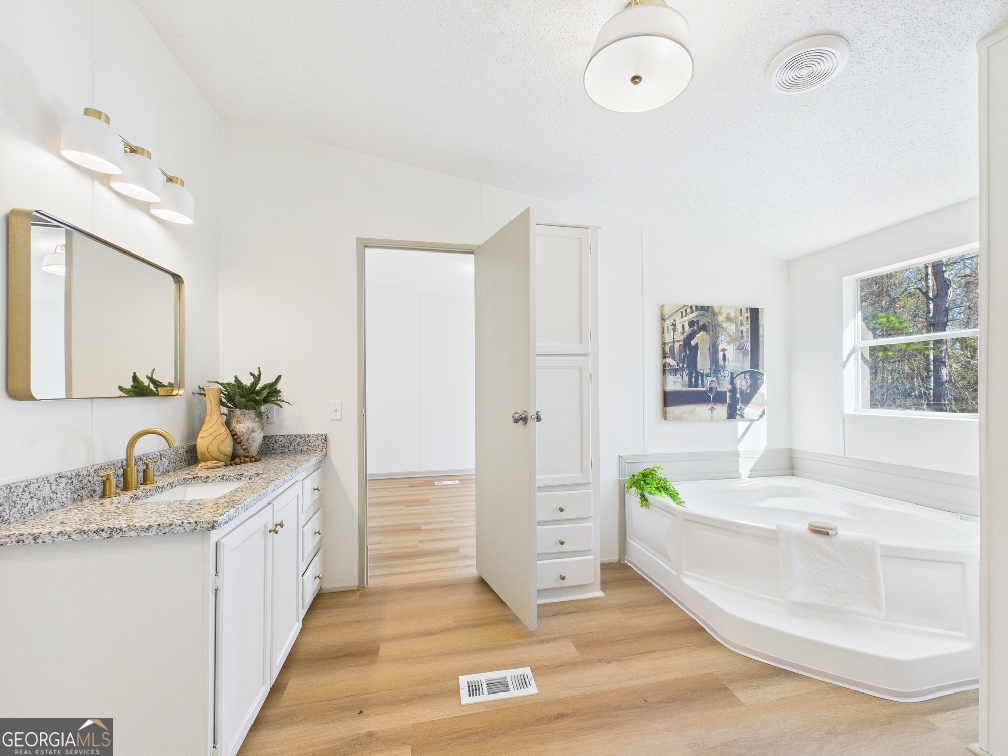 1669 Henderson Road Macon, GA 31217 - Photo 33 of 48 a bathroom with a sink double vanity granite tub shower and a mirror