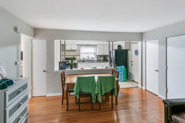 a kitchen with stainless steel appliances a table chairs refrigerator and sink
