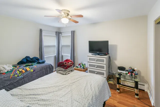 a bedroom with a bed and a flat tv screen on dresser