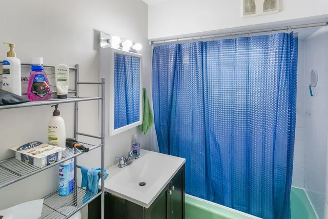 a bathroom with a sink a toilet and shower curtain