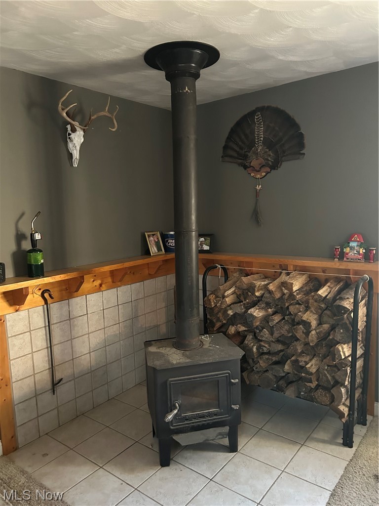 50748 Shenandoah Road Caldwell, OH 43724 - Photo 33 of 43 Room details with light tile floors, a wood stove, and ceiling fan