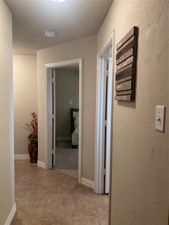 312 McAfee Street Mabank, TX 75147 - Photo 11 of 40 Corridor with a textured ceiling and a textured wall