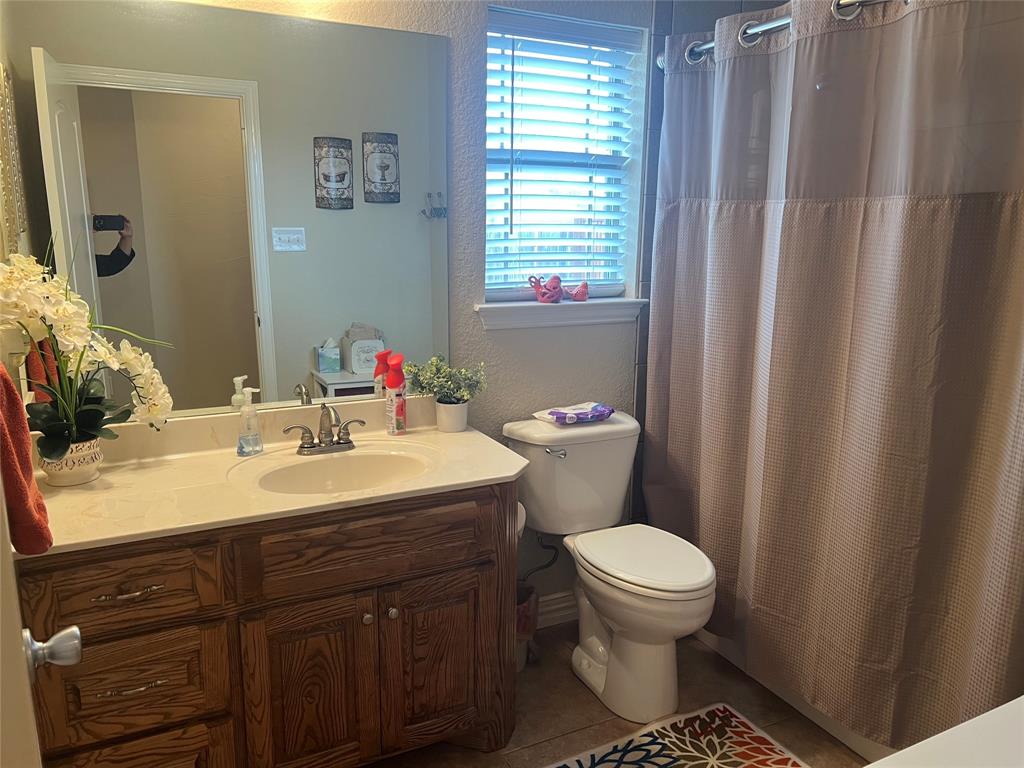 312 McAfee Street Mabank, TX 75147 - Photo 16 of 40 a bathroom with a sink toilet and a mirror