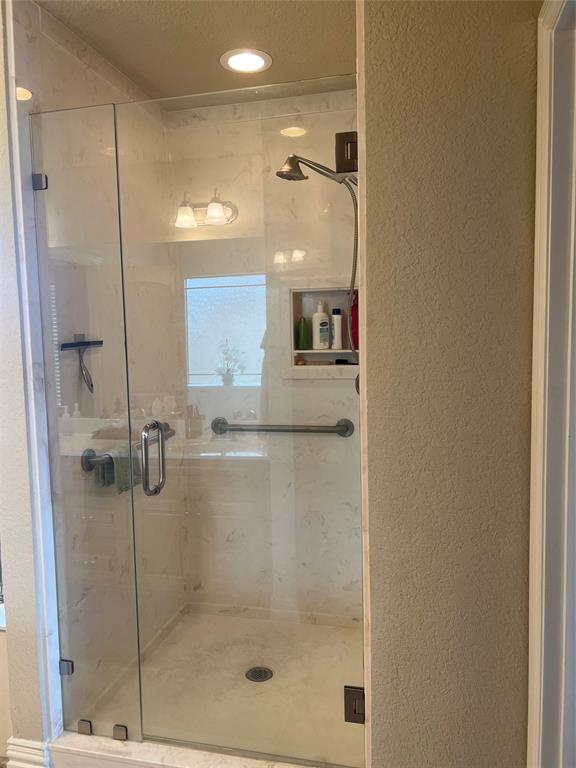 312 McAfee Street Mabank, TX 75147 - Photo 20 of 40 Bathroom featuring a textured wall and a shower stall