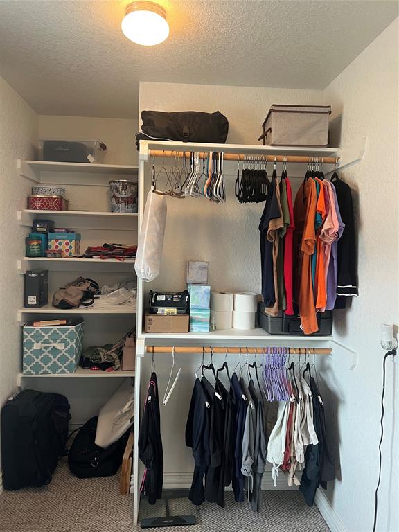 312 McAfee Street Mabank, TX 75147 - Photo 24 of 40 a view of walk in closet with clothes and shoes