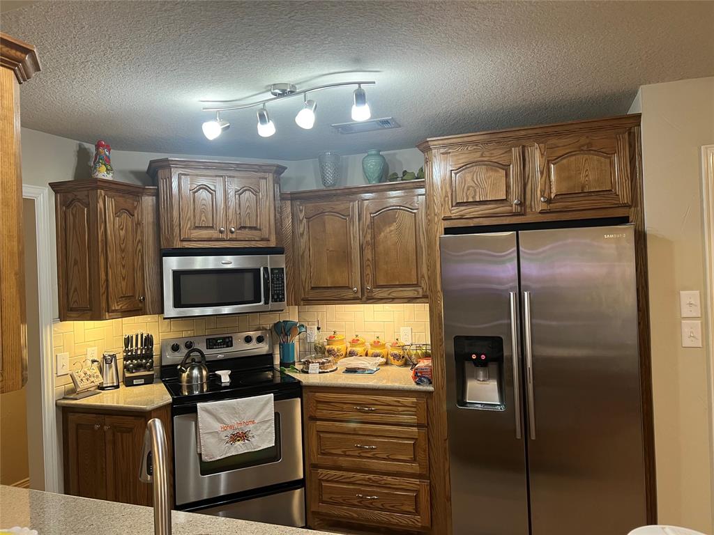 312 McAfee Street Mabank, TX 75147 - Photo 30 of 40 a kitchen with a refrigerator and a stove