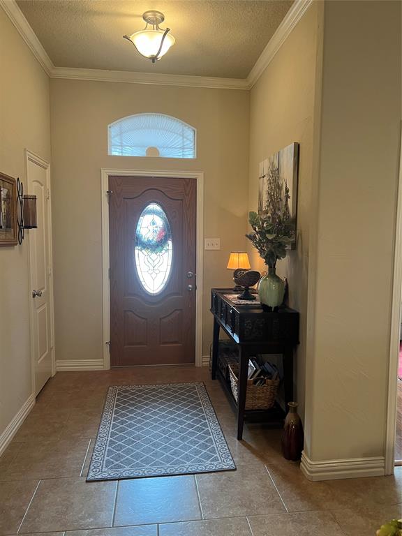 312 McAfee Street Mabank, TX 75147 - Photo 4 of 40 Foyer entrance featuring a textured ceiling and ornamental molding