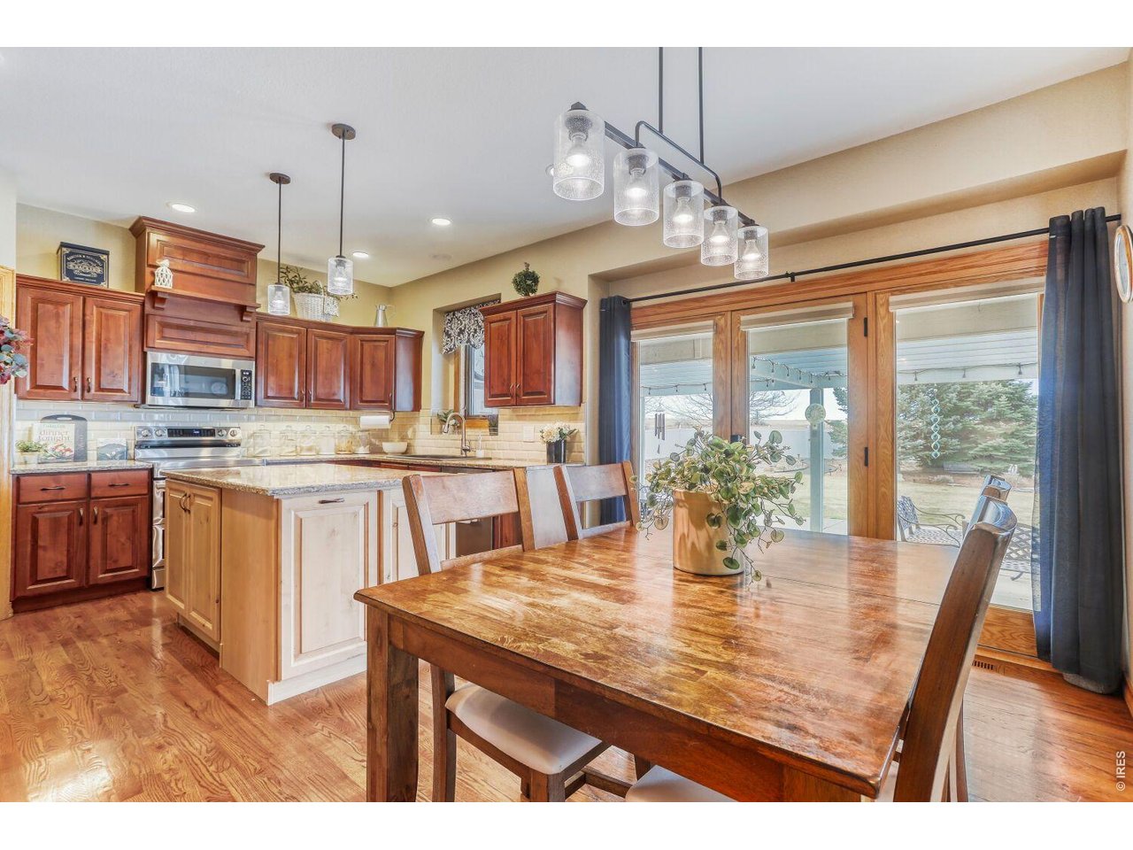 640 Valley View Road Loveland, CO 80537 - Photo 10 of 40 a dining room with kitchen island granite countertop a stove a kitchen island a dining table and chairs