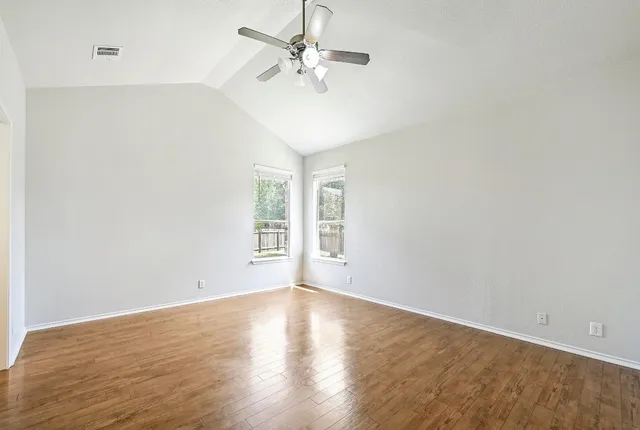 an empty room with a window and a fan