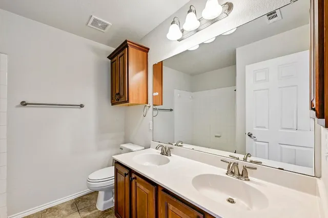 a bathroom with a sink mirror and toilet
