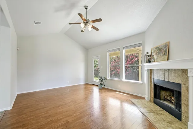 a view of an empty room with window and fire place